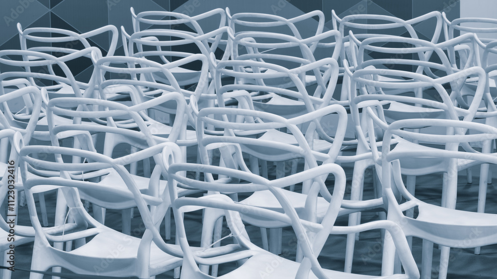 Aufkleber a row of white chairs are arranged in a line. the chairs are all facing the same direction