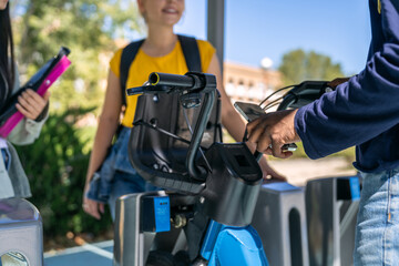University students using smartphone to rent electric scooter on campus
