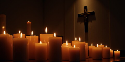 Glowing candles with crucifix in dark room