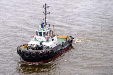 The Tugboat is Skillfully Navigating Through the Water with Unmatched Precision and Expertise