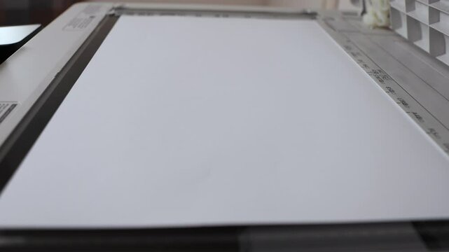 An office scanner performs the process of scanning an A3 document. Scanning paper to the MFP