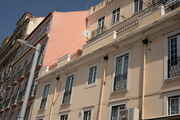 Obraz premium A row of colorful buildings with balconies and windows casting long shadows