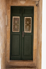 Obraz premium A charming green door with intricate wrought iron detailing in a stone doorway