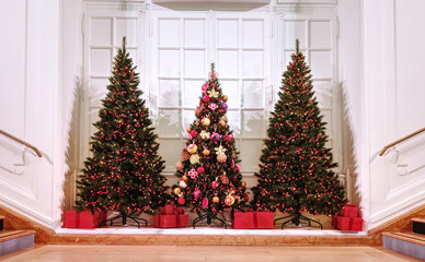 Three Christmas trees adorned with colorful ornaments on the haussmannienne design style white background. French paris style