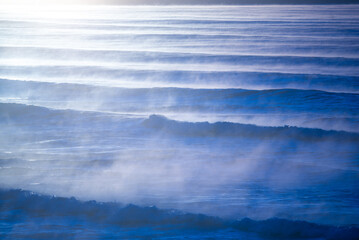 Series of ocean waves with notable mist above them