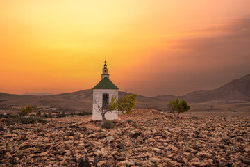 small cute white wooden chapel in a barren volcanic landscape. Sunrise, landscape shot of Ermita...