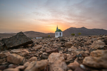 small cute white wooden chapel in a barren volcanic landscape. Sunrise, landscape shot of Ermita...