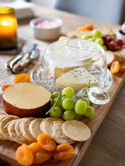 Cheese platter with crackers, grapes, apricots, and assorted cheeses