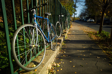Bicycles tied to a fence on the street
