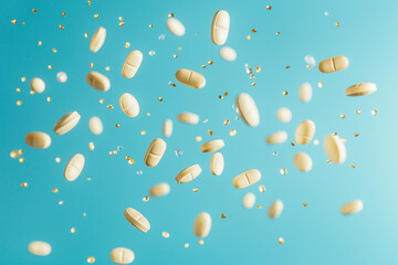 Floating Antibiotic Pills and Capsules on Blue Background for Healthcare Concept