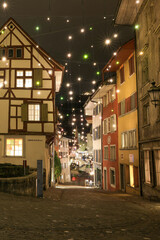 Fototapeta premium a historic house in the old town of Baden, Switzerland. Many installed light bulbs as a christmas decoration