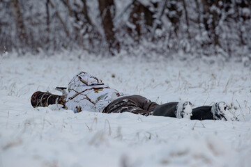Nature photographer lying in the snow taking photos