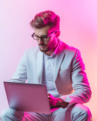 Man in White Suit Using Laptop Pink Lighting Studio Shot