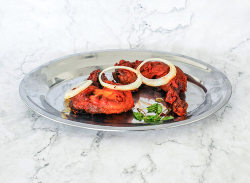 Tandoori Chicken topping with onion served in plate isolated on grey background side view of Pakistan and Indian food