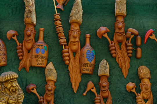 Wooden handmade souvenirs - Ukrainian cossacks with wine bottles - placed on the tablecloth
