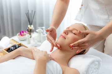 Naklejka premium Caucasian woman enjoying relaxing anti-stress head massage and pampering facial beauty skin recreation leisure in dayspa modern light ambient at luxury resort or hotel spa salon. Quiescent
