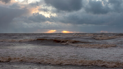 dramatic storm in the Baltic Sea, large waves crashing against the shore, blurred, unclear...