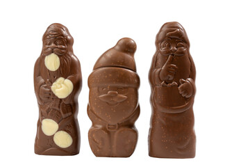 Three chocolate figures of Santa Claus, one holding a bag. The scene is festive and joyful as it represents the spirit of Christmas.