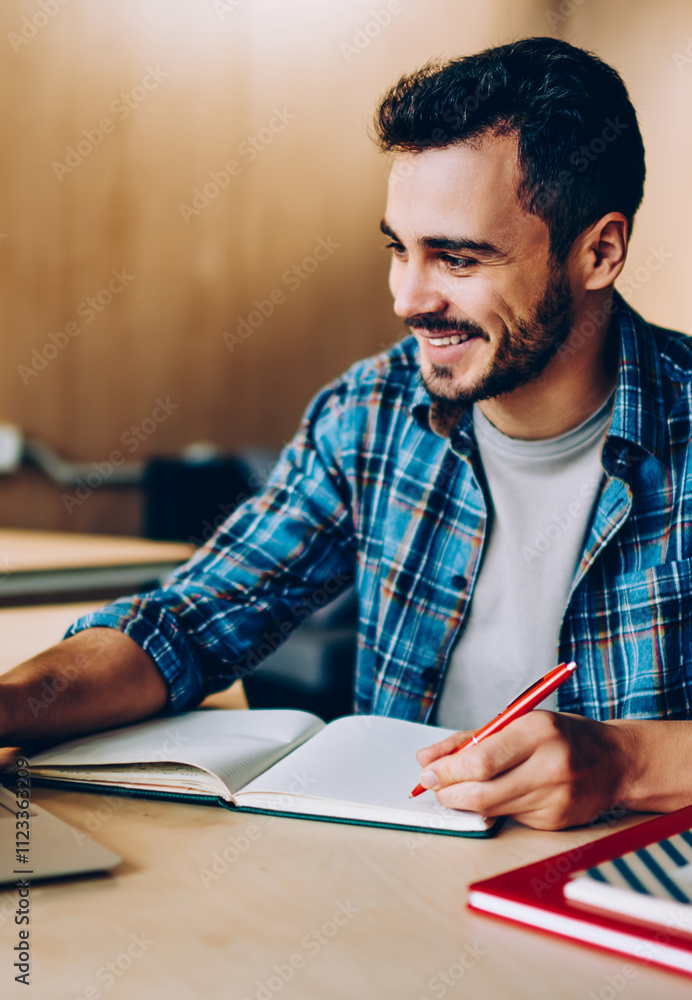 Poster cheerful young male student enjoying training webinar on laptop computer preparing coursework plan,h
