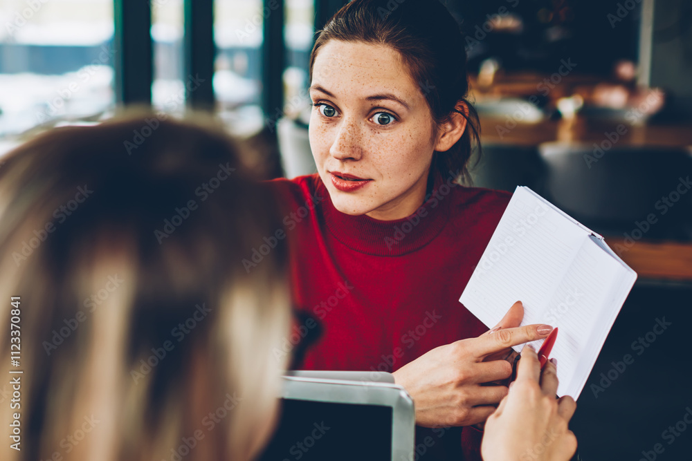 Poster wondered female tutor pointing on blank page of book and asking student about done mistake in test.t