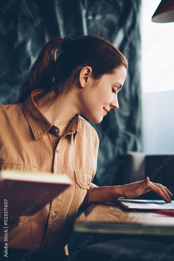 Aufkleber pensive skilled caucasian student holding textbook in hands while working on studying project at lap