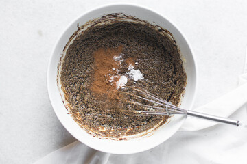 Overhead view of molasses being added and whisked into creamed butter and sugar, top view of...