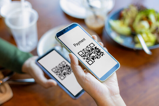 Hand using mobile phone application to scan QR code, Hands holding mobile phone, Qr code payment or cashless technology concept, Coffee shop accepting digital pay without money, Meaningless QR code.