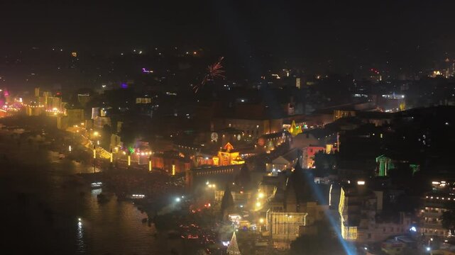 Aerial shot of banaras in dev diwali with Manikarnika Ghat Kashi Vishwanath Temple and Gyanvapi Mosque with Ghats River Ganga and Small Ships or boats Glowing City