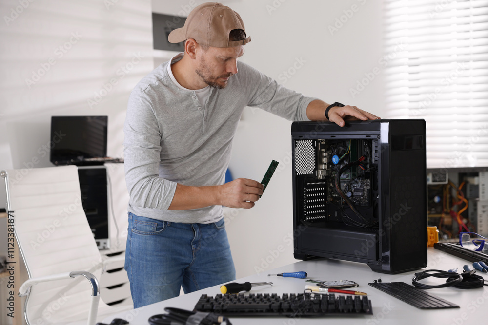 Poster man assembling new computer at white table
