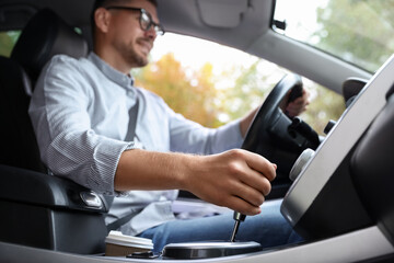 Man driving modern car, focus on gear stick