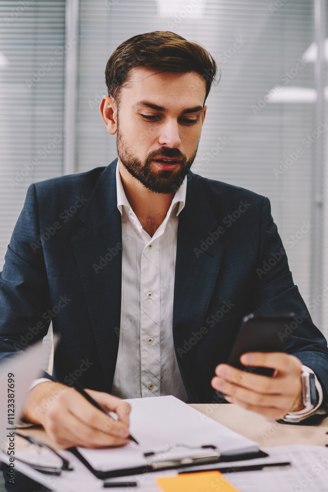 Poster pensive proud ceo rewriting information data from smartphone device working in office interior.beard