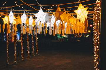 Hanging gold or yellow and white star lanterns as park decoration this Christmas holiday and yuletide season 