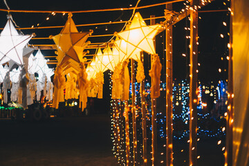 Hanging gold or yellow and white star lanterns as park decoration this Christmas holiday and yuletide season 