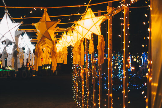 Hanging gold or yellow and white star lanterns as park decoration this Christmas holiday and yuletide season 