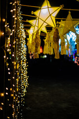 Hanging gold or yellow and white star lanterns as park decoration this Christmas holiday and yuletide season 
