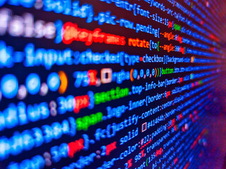Software developer programming code. Stock market graph and ticker with blue screen for stock...
