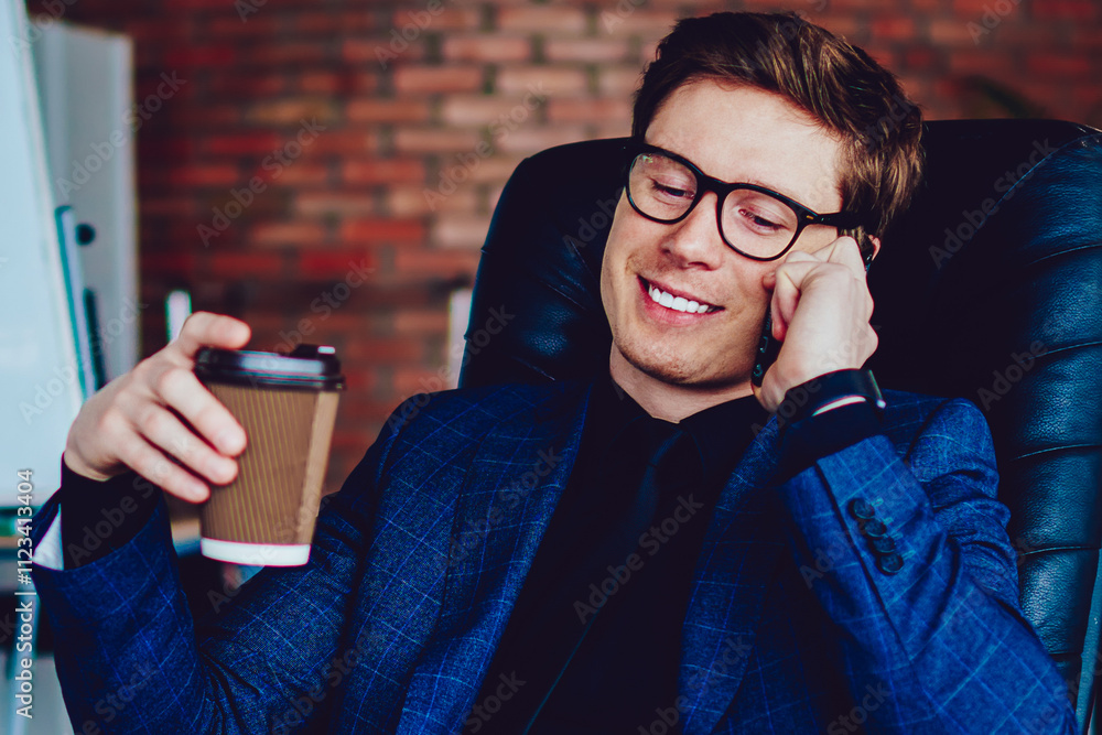 Poster successful businessman making positive conversation via app with friend while enjoying caffeine beve