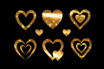Obraz premium Collection of golden hearts on a black background. Metal hearts with glitter and glitter. Packaging for February 14th. Valentine's day