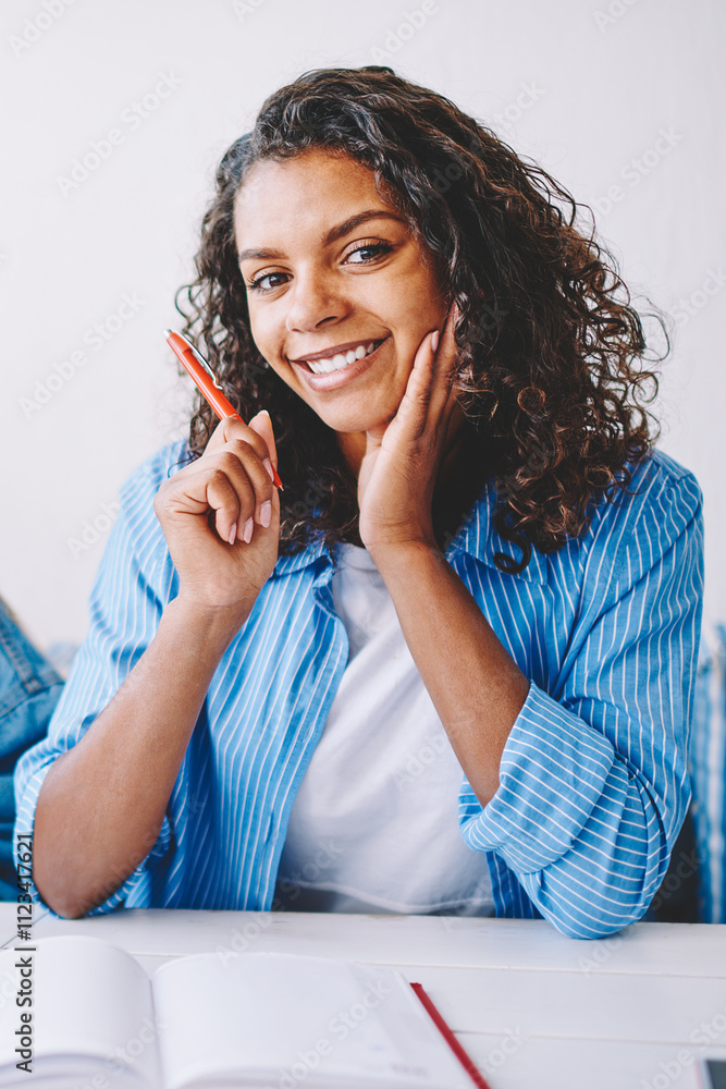 Poster portrait of positive female student looking at camera during collaboration with colleague studying t