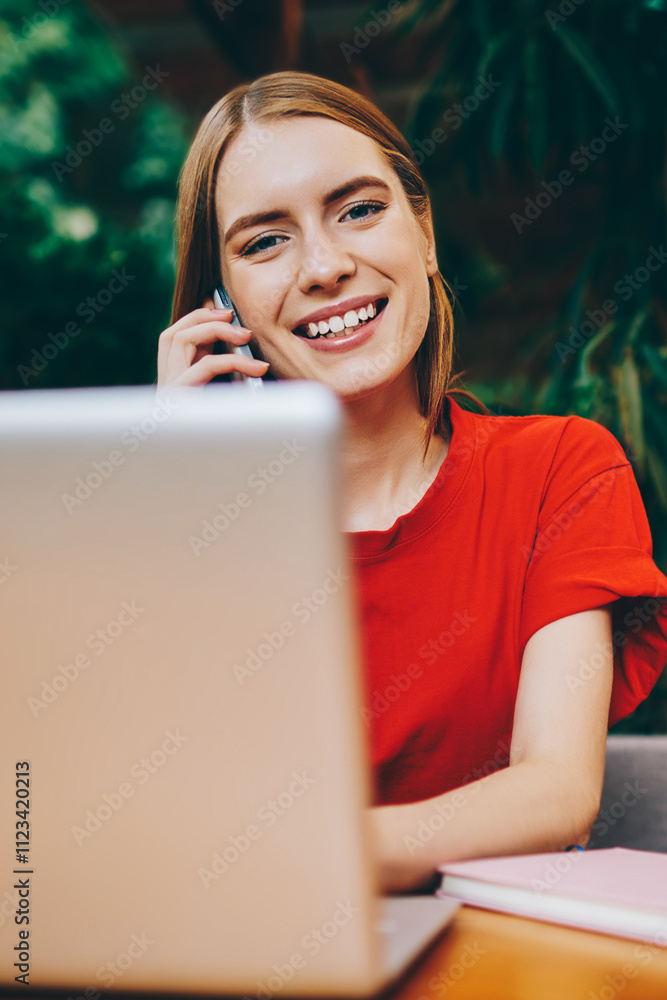 Poster portrait of smiling female software developer working online while connected to wifi and calling fri