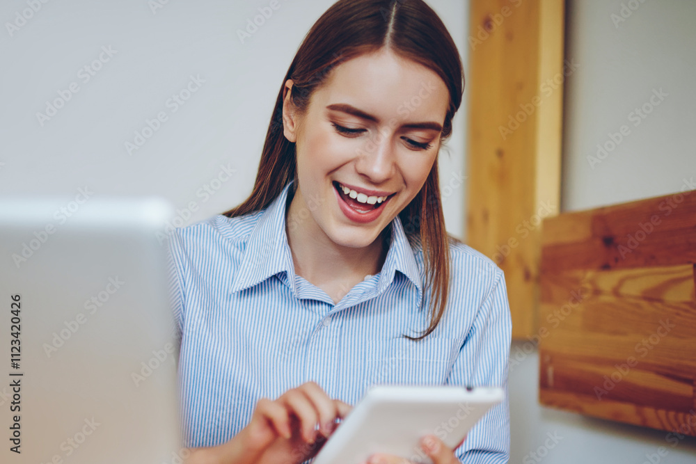Poster cheerful smiling hipster girl reading funny joke from social network using application for communica