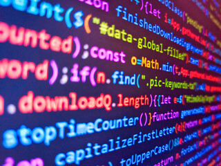 Closeup view of binary computer code with pink 1s and 0s displayed on a blue screen with focus blur...