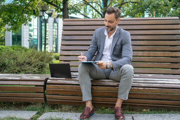 Obraz premium Business contract. Businessman signing a contract outdoor in park.