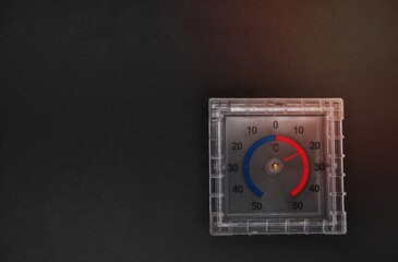thermometer with square dial on black background