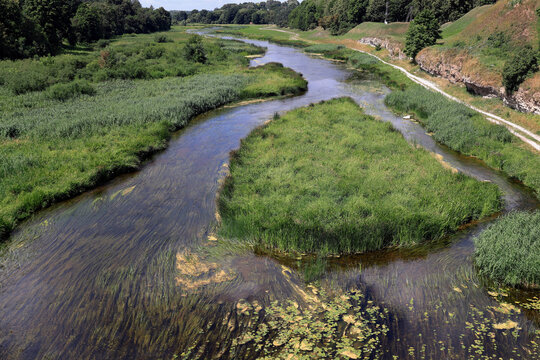 Landscape photo with a view of the Memele River flowing past green islands in Bauska, Latvia