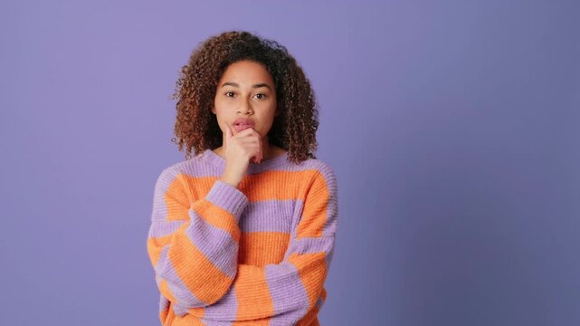 Young woman listening attentively and agreeing nodding her head on lilac background in studio
