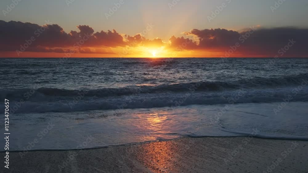 Wall mural stunning sunset over sea with vibrant colors reflecting on the water at the beach, 4k