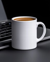 A sleek white coffee mug sits beside a laptop on a dark surface, suggesting a cozy work or study environment.