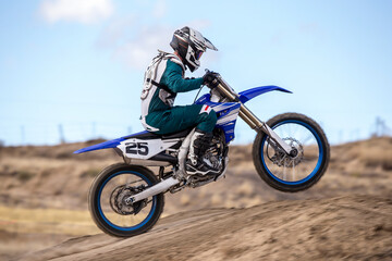Obraz premium profile view of motocross racer going off jump