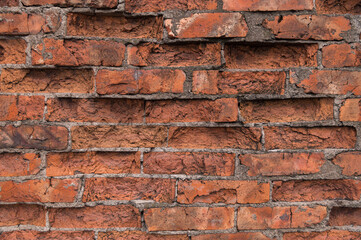 Obraz premium The old red brick wall is crumbling